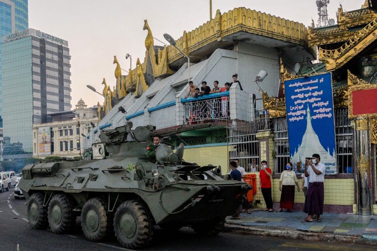 An armoured vehicle drives next to the Sule Pagoda, following days of mass protests against the military coup, in Yangon on February 14, 2021. (Photo by STR / AFP) (Photo by STR/AFP via Getty Images)