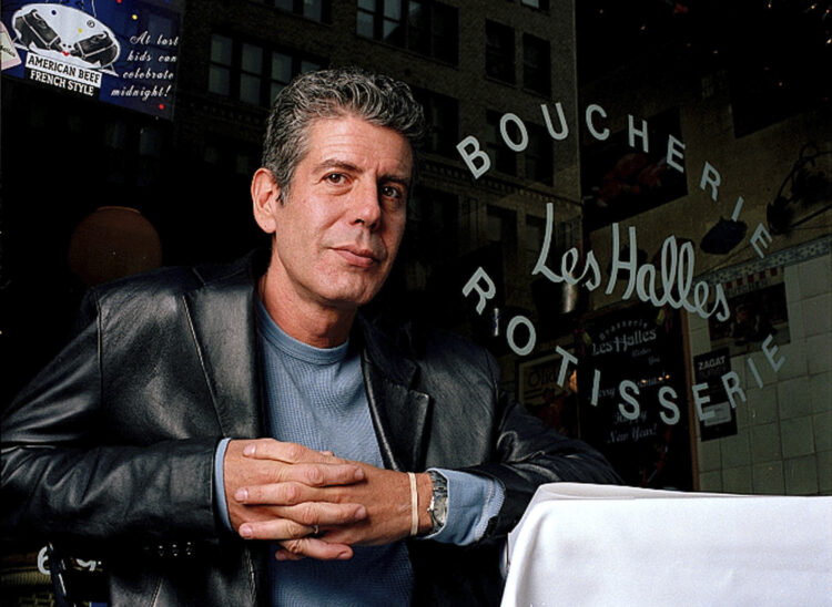 FILE - This Dec. 19, 2001 file photo shows Anthony Bourdain, the owner and chef of Les Halles restaurant, sitting at one of the tables in New York. On Friday, June 8, 2018, Bourdain was found dead in his hotel room in France, while working on his CNN series on culinary traditions around the world. (AP Photo/Jim Cooper,File)