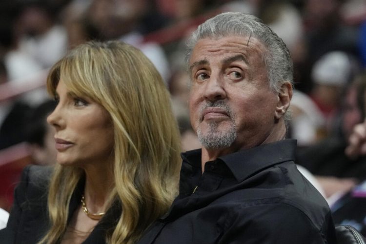 Actor Sylvester Stallone and his wife Jennifer Flavin watch the first half of an NBA basketball game between the Miami Heat and the Detroit Pistons, Wednesday, Oct. 25, 2023, in Miami. (AP Photo/Marta Lavandier)