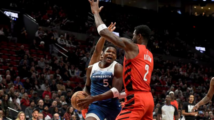 Minnesota Timberwolves guard Anthony Edwards, left, drives to the basket against Portland Trail Blazers center Deandre Ayton, right, during the first half of an NBA basketball game in Portland, Ore., Tuesday Feb. 13, 2024.