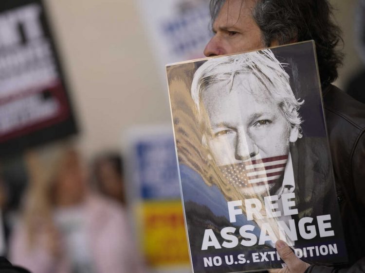 Wikileaks founder Julian Assange supporters hold placards as they gather outside Westminster Magistrates court In London, Wednesday, April 20, 2022. The court is expected to issue an extradition order to send Assange to the United States, which will then be sent to the Home Secretary Priti Patel for approval. Assange's defence will then make submissions to Patel by May 18th, in an attempt to stay the order. (AP Photo/Alastair Grant)