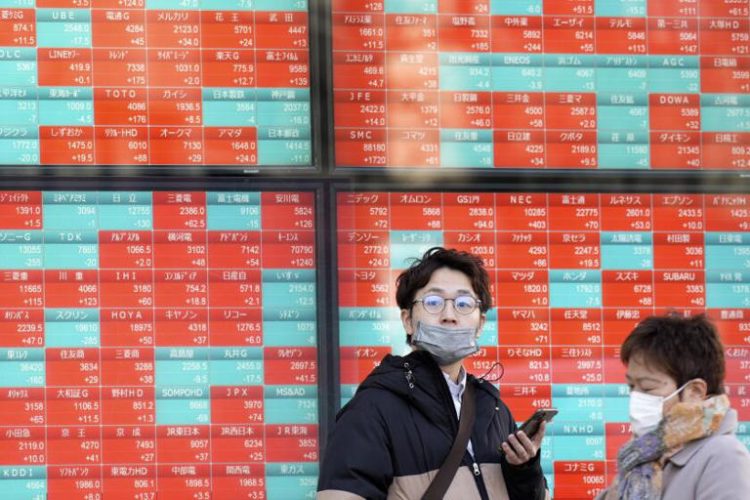 People stand in front of an electronic stock board showing Japan's stock prices at a securities firm in Tokyo last month. ((Eugene Hoshiko / Associated Press))
© Provided by LA Times