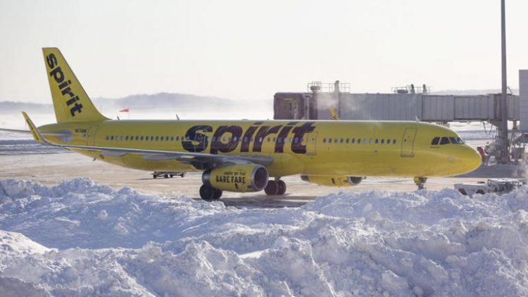 A Spirit Airlines plane sits next to a large pile of snow near an airport gate.
© Photo: Scott Eisen (Getty Images)