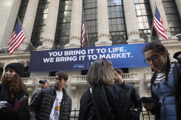 People walk past the New York Stock Exchange. Wall Street edged back further from its record heights on Monday. ((Associated Press))
© Provided by LA Times