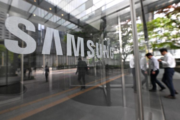 People walk past the Samsung logo displayed on a glass door at the company's Seocho building in Seoul on April 30, 2024. Samsung has mandated its executives work a six-day work week.
© JUNG YEON-JE/AFP via Getty Images