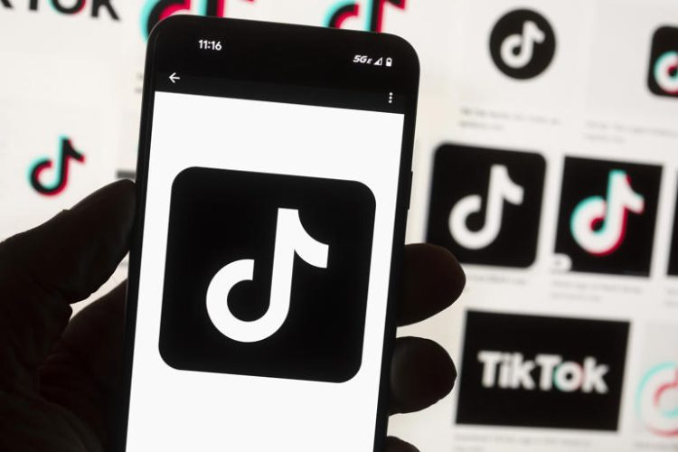 The TikTok logo is displayed on a mobile phone in front of a computer screen, Oct. 14, 2022, in Boston. On Tuesday, May 7, 2024, TikTok and its Chinese parent company ByteDance filed suit against the U.S. federal government to challenge a law that would force the sale of ByteDance's stake or face a ban, saying that the law is unconstitutional.