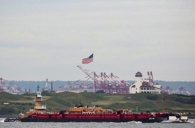 A tug boat pushes an oil barge through New York Harbor in New York City, U.S., May 24, 2022. REUTERS/Brendan McDermid/File Photo