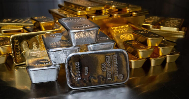 Gold and silver bars of various sizes lie in a safe on a table at the precious metals dealer Pro Aurum.