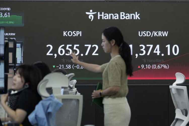 Currency traders work near the screen showing the Korea Composite Stock Price Index (KOSPI), left, and the foreign exchange rate between U.S. dollar and South Korean won at the foreign exchange dealing room of the KEB Hana Bank headquarters in Seoul, South Korea, Thursday, May 30, 2024.
