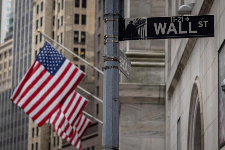 The sign for Wall Street is seen with US flags outside the New York Stock Exchange in New York on June 16, 2022. (YUKI IWAMURA/AFP via Getty Images)