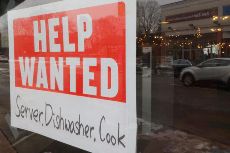 A “Help Wanted” sign hangs in restaurant window in Medford, Massachusetts, U.S., January 25, 2023. REUTERS/Brian Snyder/File Photo