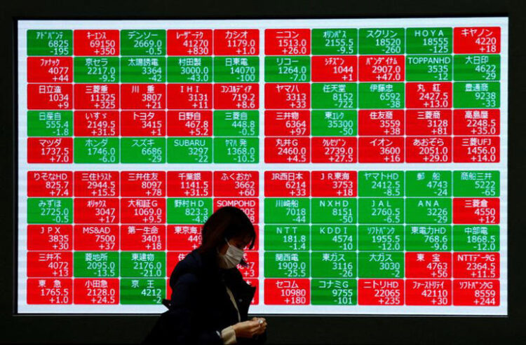 A passerby walks past Japan's Nikkei stock prices quotation board outside a brokerage in Tokyo, Japan February 19, 2024. REUTERS/Issei Kato/File Photo