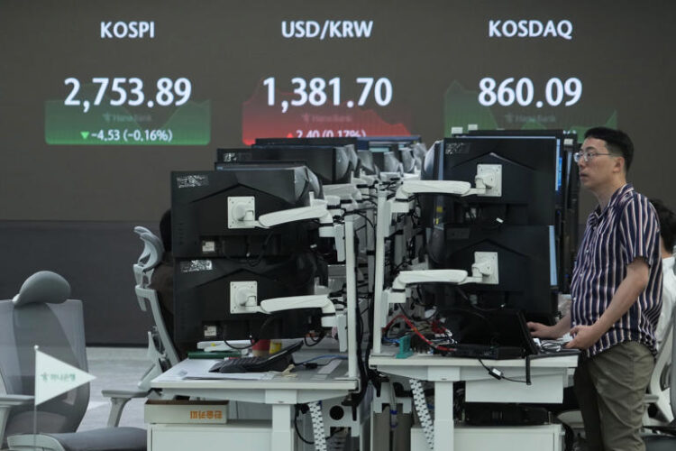 A currency trader watches monitors near the screen showing the Korea Composite Stock Price Index (KOSPI), top left, and the foreign exchange rate between U.S. dollar and South Korean won, top center, at the foreign exchange dealing room of the KEB Hana Bank headquarters in Seoul, South Korea, Monday, June 17, 2024. (AP Photo/Ahn Young-joon)
