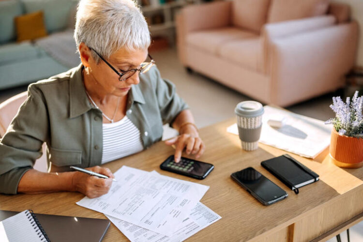 Senior woman calculating finances at home