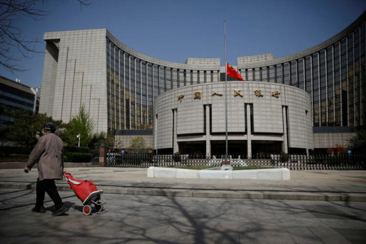 The Chinese national flag flies at half-mast at the headquarters of the People's Bank of China, the central bank (PBOC), as China holds a national mourning for those who died of the coronavirus disease (COVID-19), on the Qingming tomb-sweeping festival in Beijing, China April 4, 2020. REUTERS/Carlos Garcia Rawlins/File photo