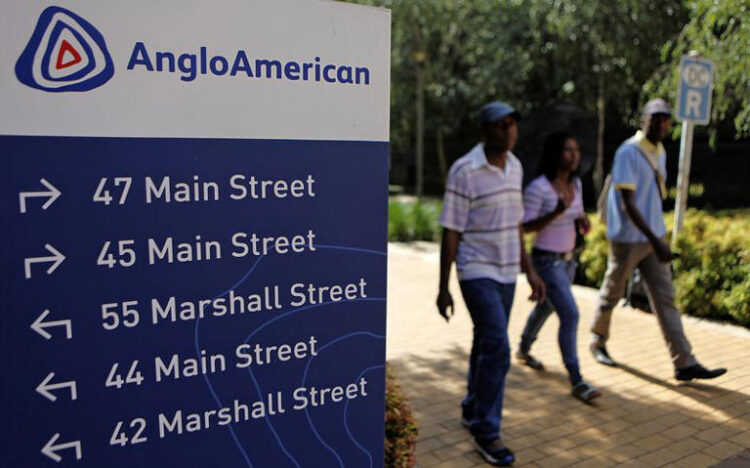 People walk past a board outside the Anglo American offices in Johannesburg January 8, 2013. REUTERS/Siphiwe Sibeko/ File Photo