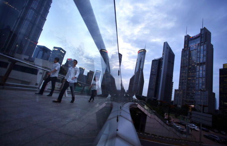 People cross a bridge at Pudong financial district in Shanghai August 11, 2014. REUTERS/Carlos Barria/File photo