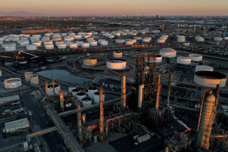 A view of the Phillips 66 Company's Los Angeles Refinery (foreground), which processes domestic & imported crude oil into gasoline, aviation and diesel fuels, and storage tanks for refined petroleum products at the Kinder Morgan Carson Terminal (background), at sunset in Carson, California, U.S., March 11, 2022. REUTERS/Bing Guan/File Photo