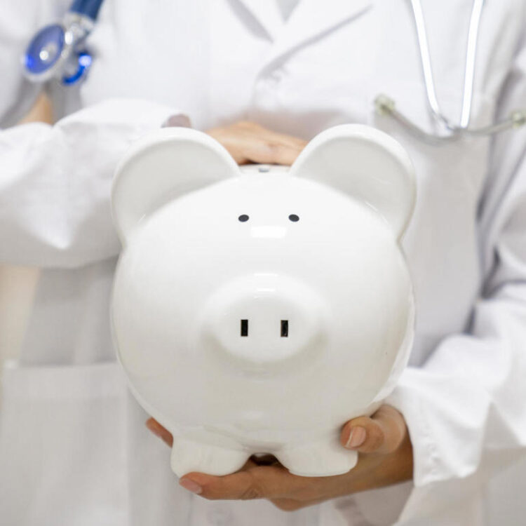 Doctor holding a piggybank at the hospital - health insurance