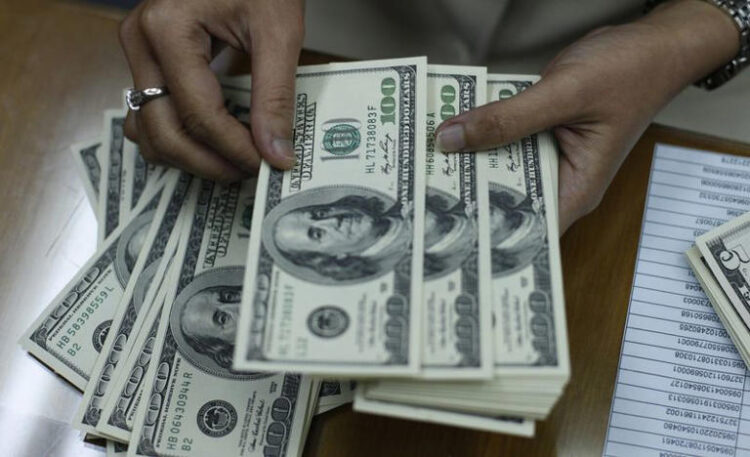 An employee counts U.S. dollar notes at a money changer in Jakarta January 27, 2010. REUTERS/Beawiharta/File Photo