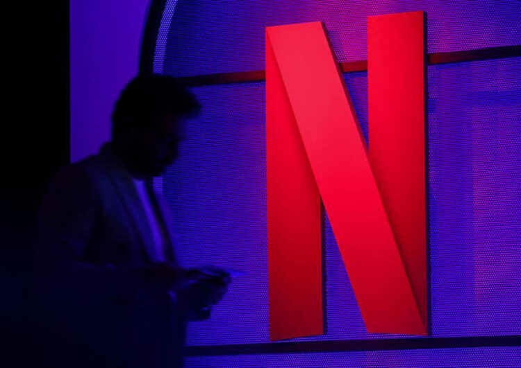 FILE PHOTO: A man stands next to a logo of Netflix during an event in Mumbai, India, February 29, 2024. REUTERS/Francis Mascarenhas/File Photo