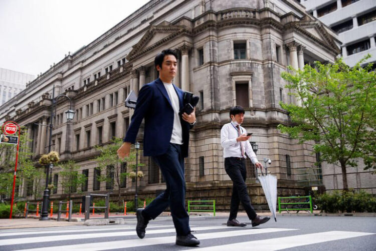 People walk in front of the bank of Japan building in Tokyo, Japan, April 7, 2023. REUTERS/Androniki Christodoulou