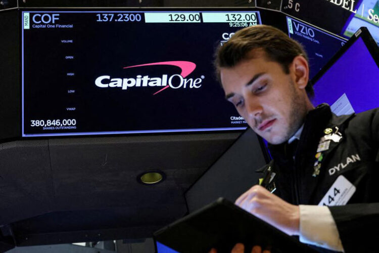 A screen displays the logo and trading information for Capital One Financial as a trader works on the floor at the New York Stock Exchange in New York City, U.S., February 20, 2024. REUTERS/Brendan McDermid/File Photo