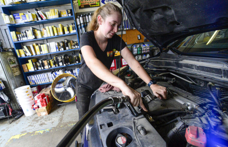 Elise Lacroix, owner of Stop & Go in Brattleboro, Vt., changes the oil on a vehicle at her shop on July 15, 2024