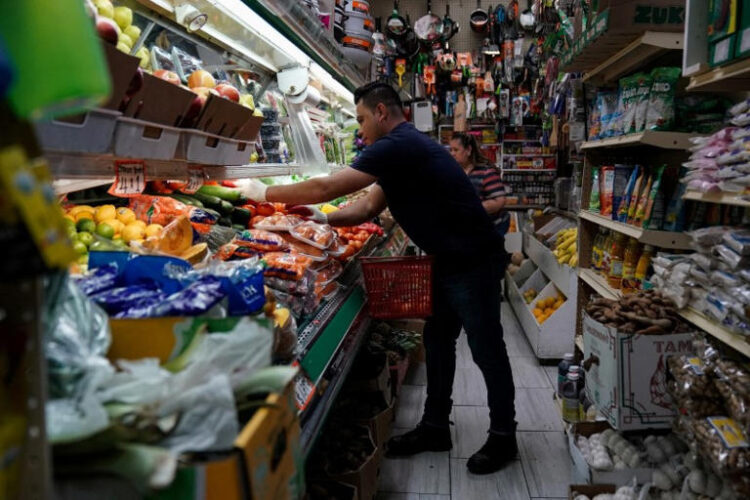 A person arranges groceries in El Progreso Market in the Mount Pleasant neighborhood of Washington, D.C., U.S., August 19, 2022. REUTERS/Sarah Silbiger/File Photo