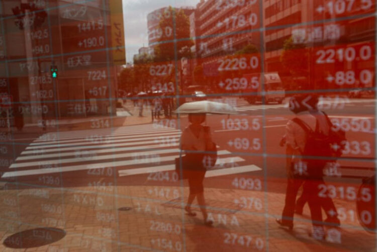 A woman is reflected on an electronic stock quotation board outside a brokerage in Tokyo, Japan, August 6, 2024. REUTERS/Willy Kurniawan/File Photo